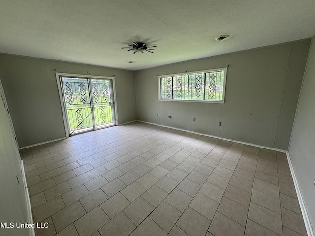 3327 Casa Grande Cir, Jackson, MS 39209 - tiled empty room with baseboards, ceiling fan, and a textured ceiling