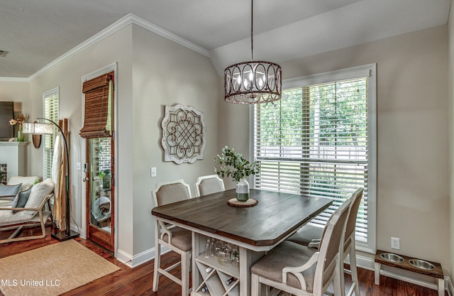 dining space with crown molding, a chandelier, lofted ceiling, and dark hardwood / wood-style flooring