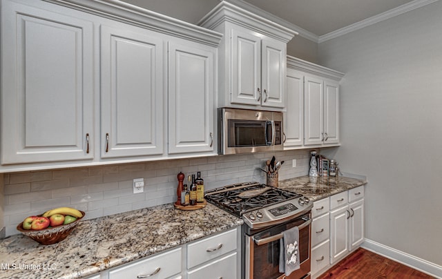 kitchen featuring appliances with stainless steel finishes, light stone counters, white cabinets, dark wood-type flooring, and crown molding