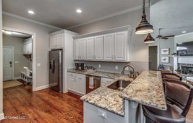 kitchen with a kitchen bar, stainless steel appliances, pendant lighting, white cabinets, and dark hardwood / wood-style floors