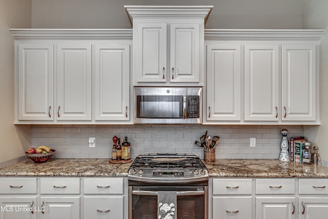 kitchen featuring backsplash, appliances with stainless steel finishes, and white cabinetry