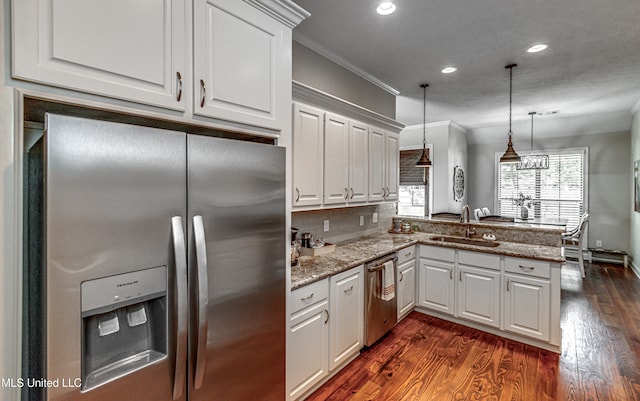 kitchen featuring stainless steel appliances, sink, kitchen peninsula, and white cabinets