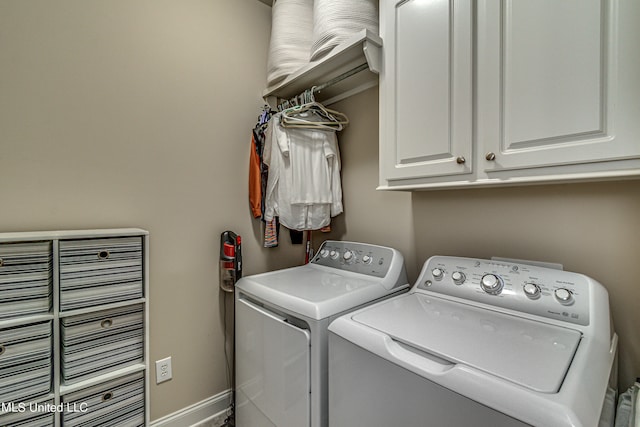 clothes washing area featuring cabinets and washer and clothes dryer