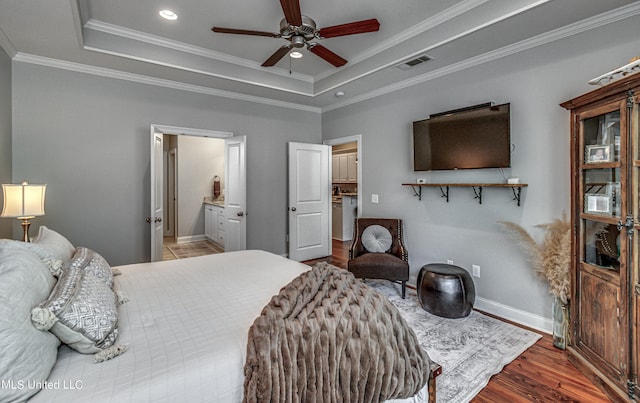 bedroom featuring crown molding, hardwood / wood-style flooring, a tray ceiling, and ceiling fan