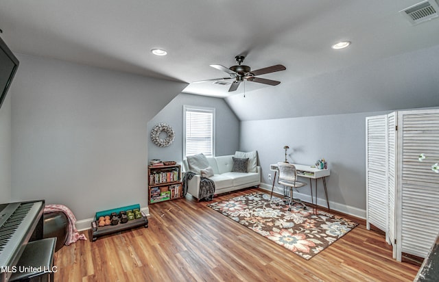 living area with ceiling fan, hardwood / wood-style flooring, and lofted ceiling