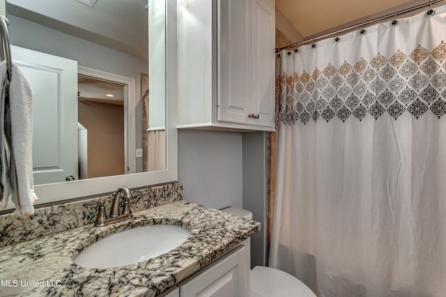 bathroom with vanity, curtained shower, and toilet