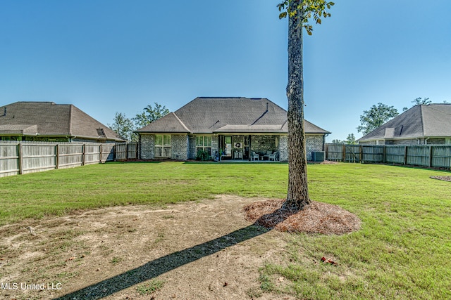 rear view of property with a yard and central AC unit