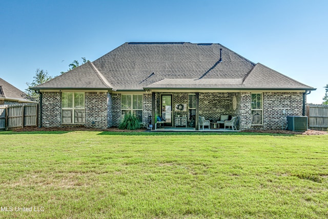 back of house featuring central air condition unit, a patio area, and a yard