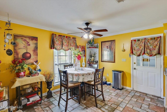 dining space featuring crown molding, a ceiling fan, and baseboards