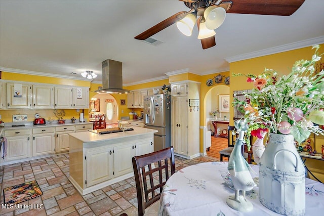 kitchen with light countertops, arched walkways, stainless steel appliances, island range hood, and ornamental molding