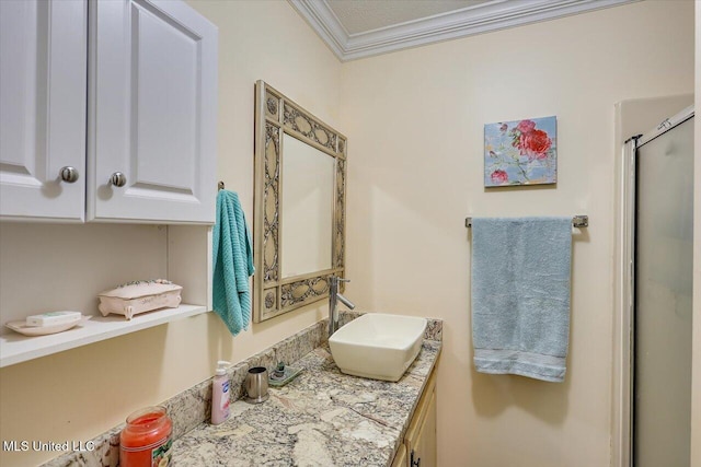 bathroom with vanity, ornamental molding, and a shower with door