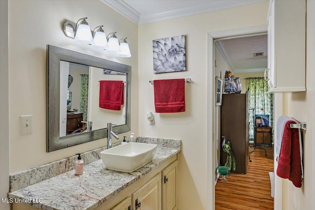 bathroom with visible vents, ornamental molding, wood finished floors, and vanity