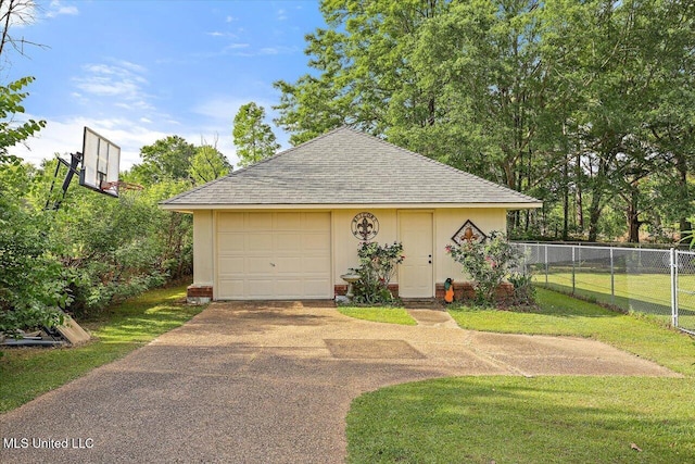 garage with fence and aphalt driveway
