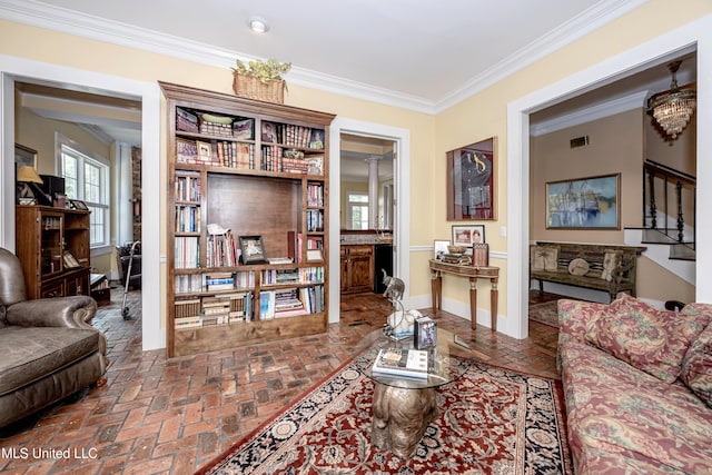 living area featuring visible vents, crown molding, brick floor, and baseboards