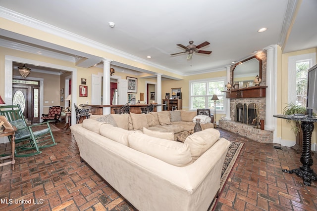 living room featuring recessed lighting, a ceiling fan, ornate columns, ornamental molding, and brick floor
