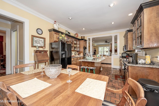 dining room with crown molding, baseboards, recessed lighting, decorative columns, and brick floor