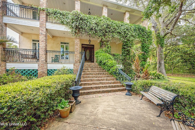 doorway to property featuring a porch and stucco siding