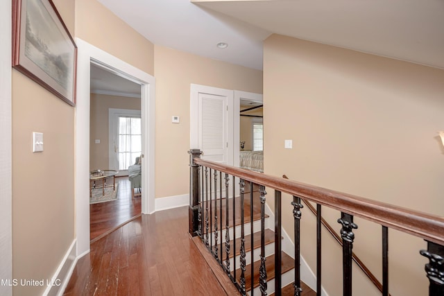 hall featuring an upstairs landing, dark wood-style flooring, recessed lighting, and baseboards