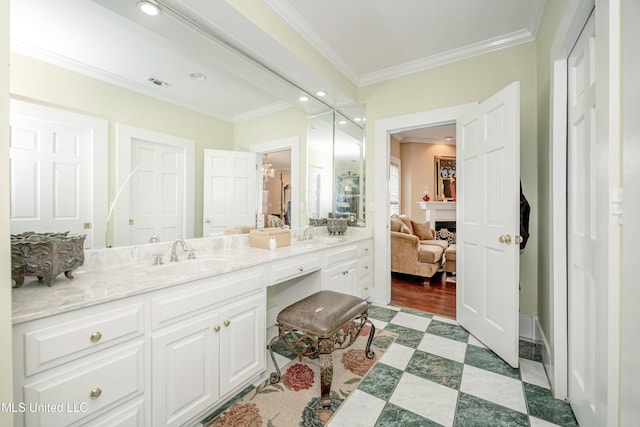 ensuite bathroom with a sink, connected bathroom, crown molding, double vanity, and visible vents