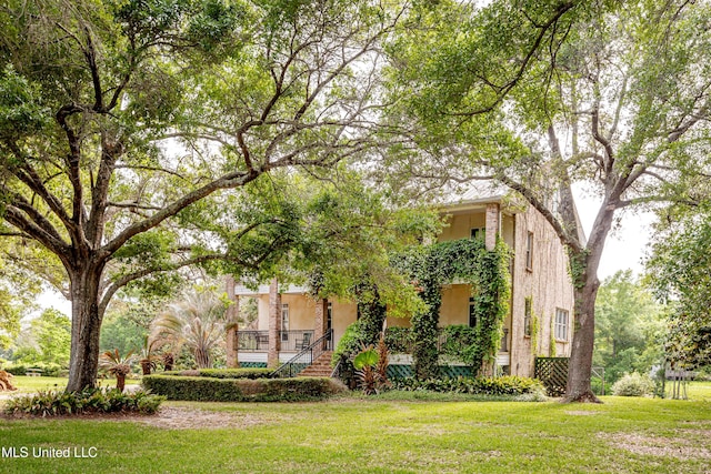 obstructed view of property featuring stucco siding and a front lawn