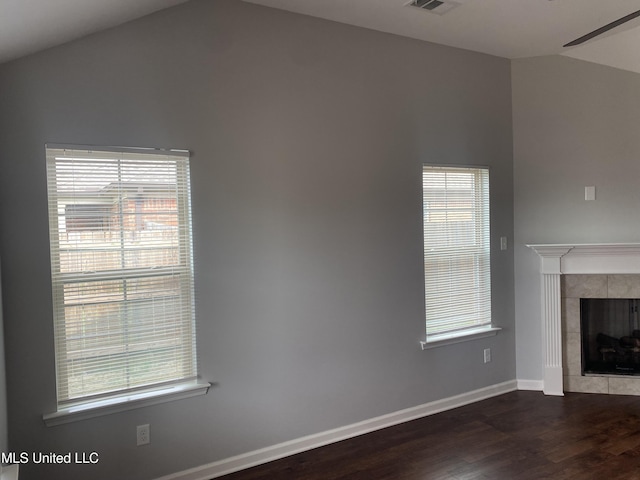 9078 Mallard Park Blvd, Walls, MS 38680 - unfurnished living room featuring lofted ceiling, dark wood finished floors, baseboards, a tiled fireplace, and healthy amount of natural light