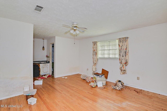 interior space featuring hardwood / wood-style floors, ceiling fan, and a textured ceiling