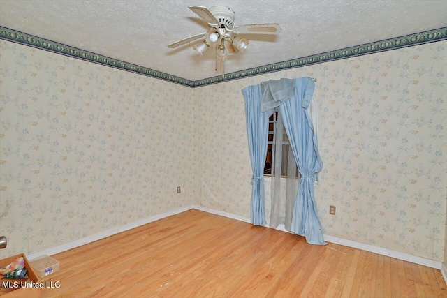 spare room with ceiling fan, hardwood / wood-style floors, and a textured ceiling