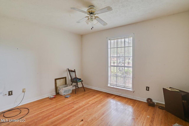 unfurnished room with ceiling fan, light hardwood / wood-style floors, and a textured ceiling