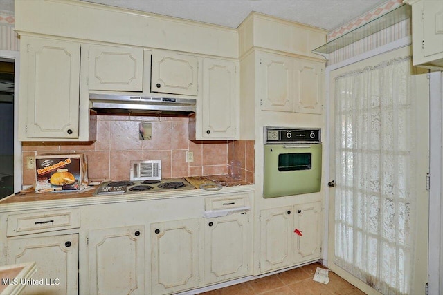 kitchen featuring tasteful backsplash, oven, light tile patterned flooring, and stainless steel gas cooktop