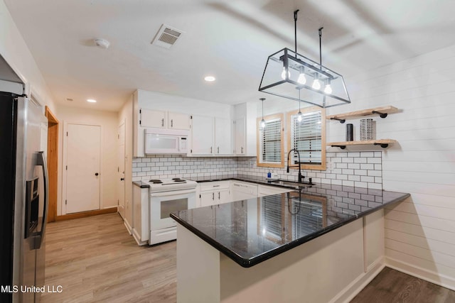 118 Dogwood Trl, Brandon, MS 39047 - kitchen with white appliances, a sink, a peninsula, light wood-type flooring, and backsplash
