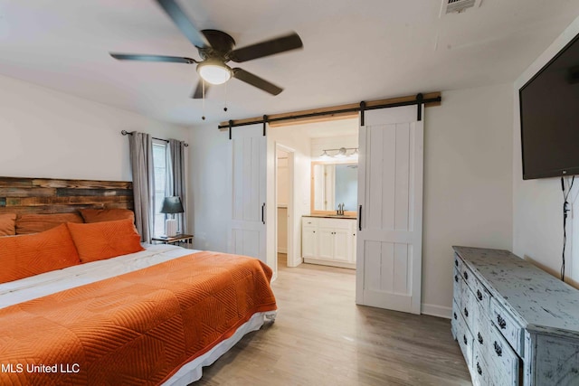 118 Dogwood Trl, Brandon, MS 39047 - bedroom featuring a barn door, a sink, light wood-type flooring, ensuite bath, and a ceiling fan