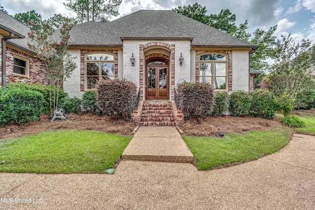 french country inspired facade featuring french doors and roof with shingles