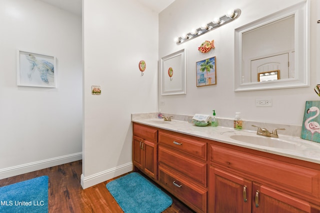 223 Sycamore St, Bay Saint Louis, MS 39520 - full bathroom featuring double vanity, a sink, baseboards, and wood finished floors