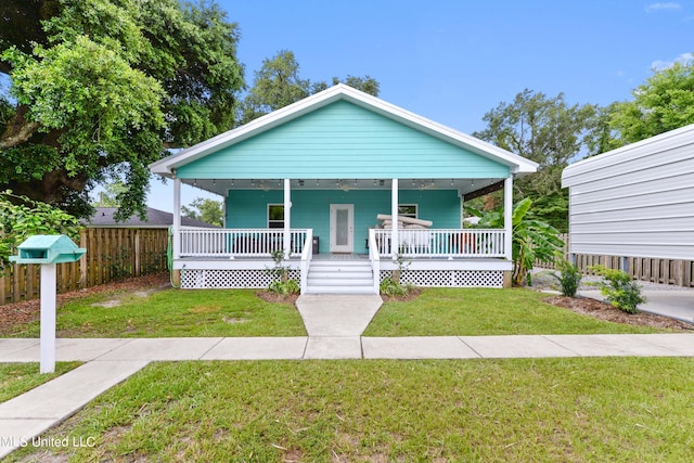 223 Sycamore St, Bay Saint Louis, MS 39520 - bungalow-style home with covered porch, fence, and a front lawn