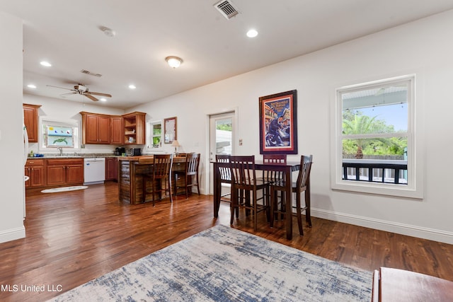 223 Sycamore St, Bay Saint Louis, MS 39520 - dining room with visible vents, dark wood-style flooring, and a healthy amount of sunlight