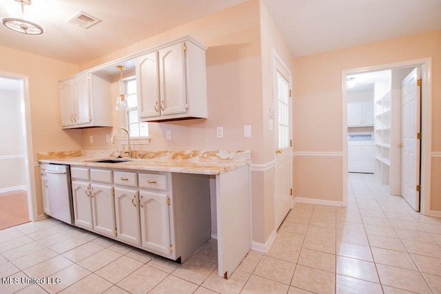 kitchen with dishwasher, white cabinetry, sink, and light tile patterned floors