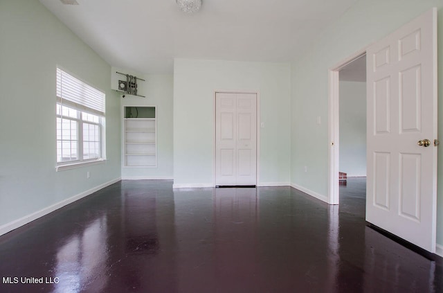 spare room featuring built in shelves