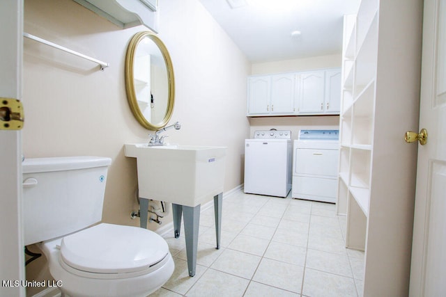 bathroom with toilet, independent washer and dryer, and tile patterned floors