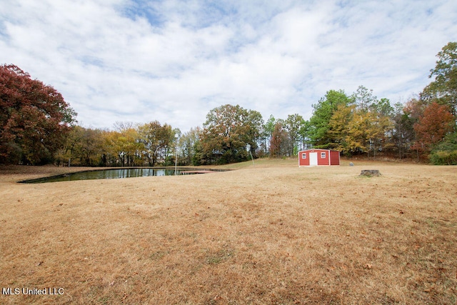 view of yard featuring a water view and a shed