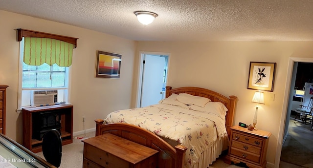 bedroom with carpet floors, a textured ceiling, baseboards, and cooling unit