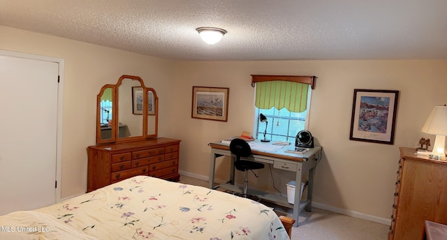 bedroom with a textured ceiling, carpet floors, and baseboards