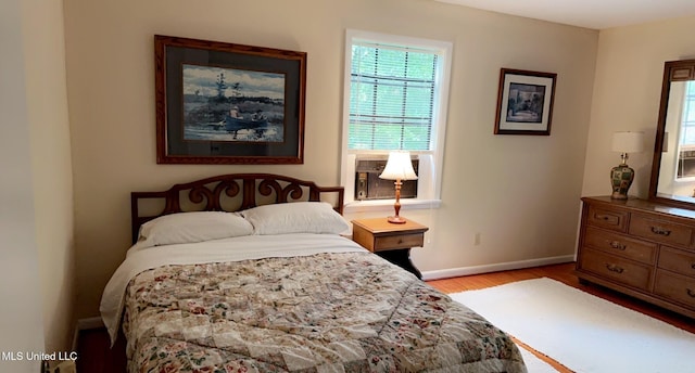 bedroom with light wood-type flooring, baseboards, and cooling unit