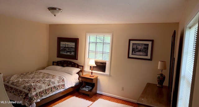 bedroom with light wood-style flooring and baseboards