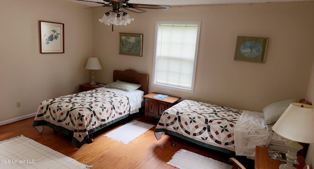 bedroom featuring ceiling fan, baseboards, and wood finished floors