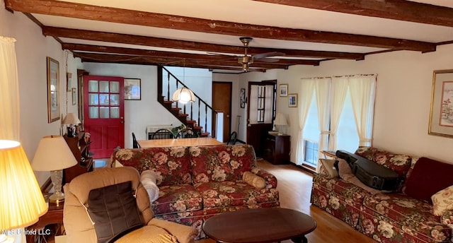 living area featuring stairs, ceiling fan, beamed ceiling, and wood finished floors