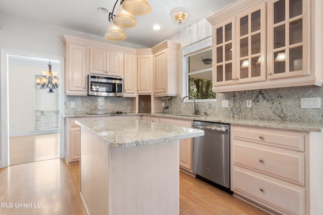 kitchen with hanging light fixtures, stainless steel appliances, and tasteful backsplash