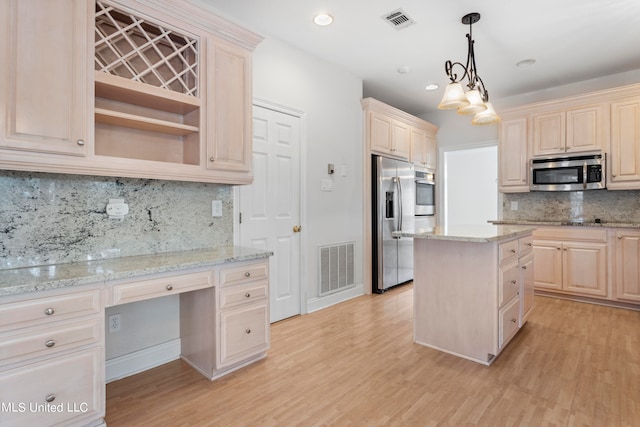 kitchen with tasteful backsplash, appliances with stainless steel finishes, light wood-type flooring, decorative light fixtures, and a center island