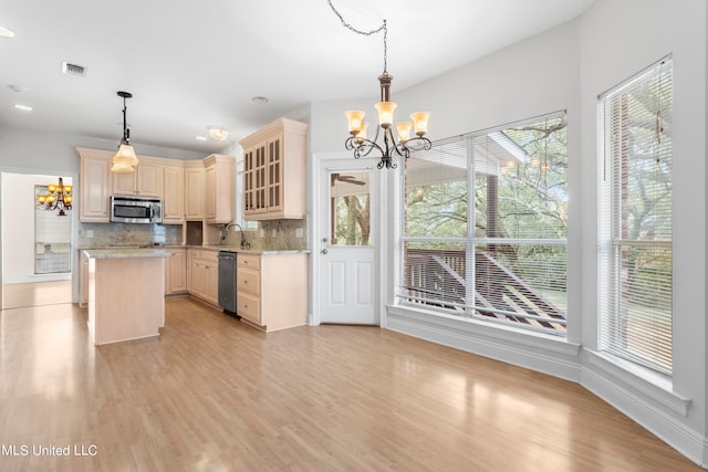 kitchen featuring decorative backsplash, decorative light fixtures, stainless steel appliances, and a wealth of natural light