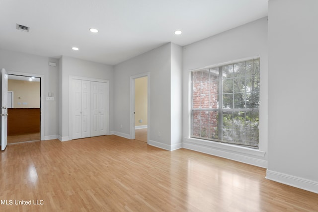 unfurnished bedroom with a closet and light wood-type flooring