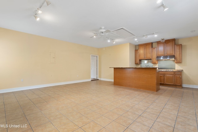 kitchen featuring kitchen peninsula, track lighting, and light tile patterned floors